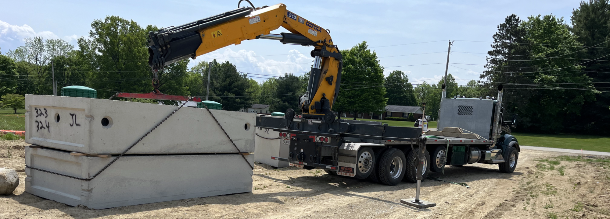 Stiger truck unloading concrete tanks.