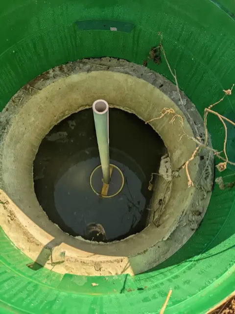 view looking down an open riser on a septic tank