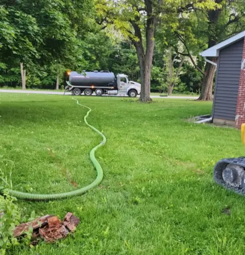 truck parked on the road pumping a residential tank